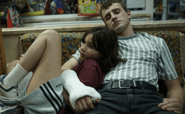 11-year-old Sophie leaning on her napping father Calum (Paul Mescal) in a cast