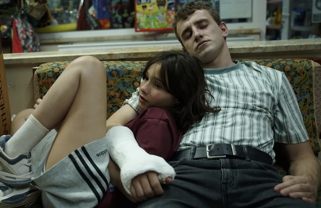 11-year-old Sophie leaning on her napping father Calum (Paul Mescal) in a cast