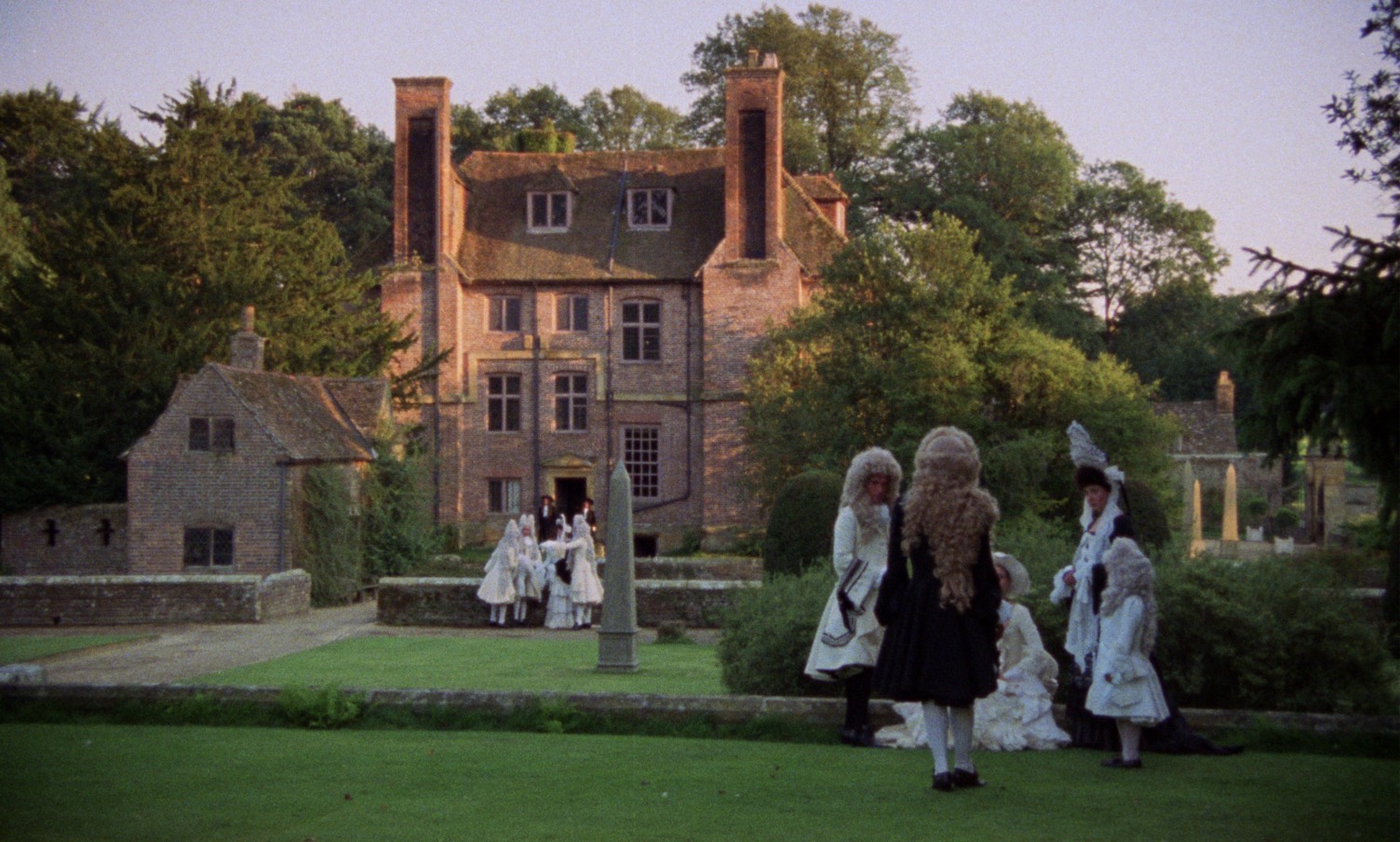 Aristocrats talking in two groups in the front yard of a big English castle