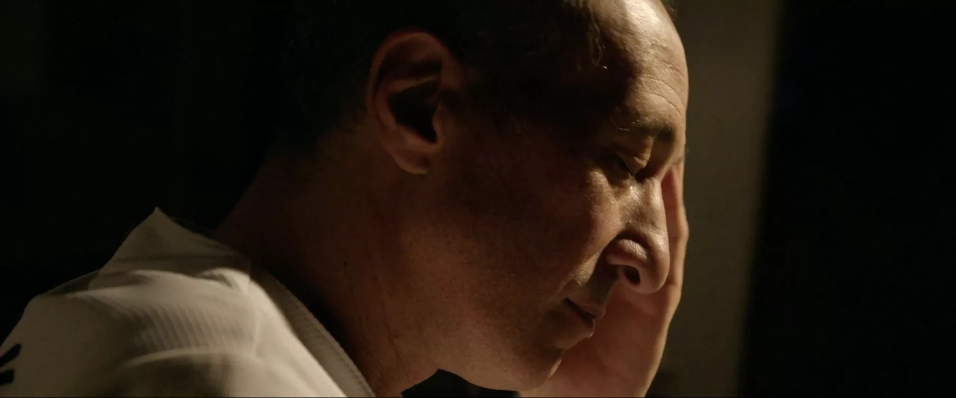 A pensive man (Greg Laemmle) looking down in profile