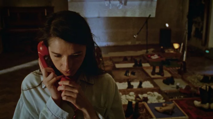 A young woman speaking on the old-style phone in a foley room full of different substances
