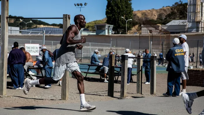 Black San Quentin prisoner running in a prison yard as a member that tells the story of the 1000 Mile Club, the prison's long distance running club