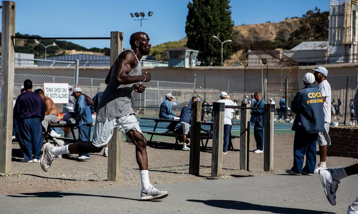 Black San Quentin prisoner running in a prison yard as a member that tells the story of the 1000 Mile Club, the prison's long distance running club