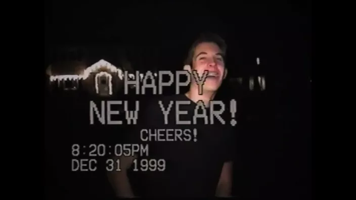 Guy on a VHS footage with Happy New Year note on top of him