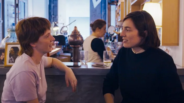 Two lesbian women talking at a bar