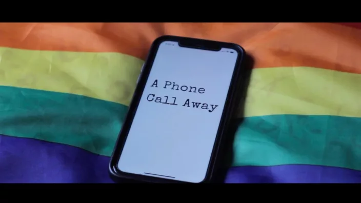 An iPhone laying on tip of the rainbow flag