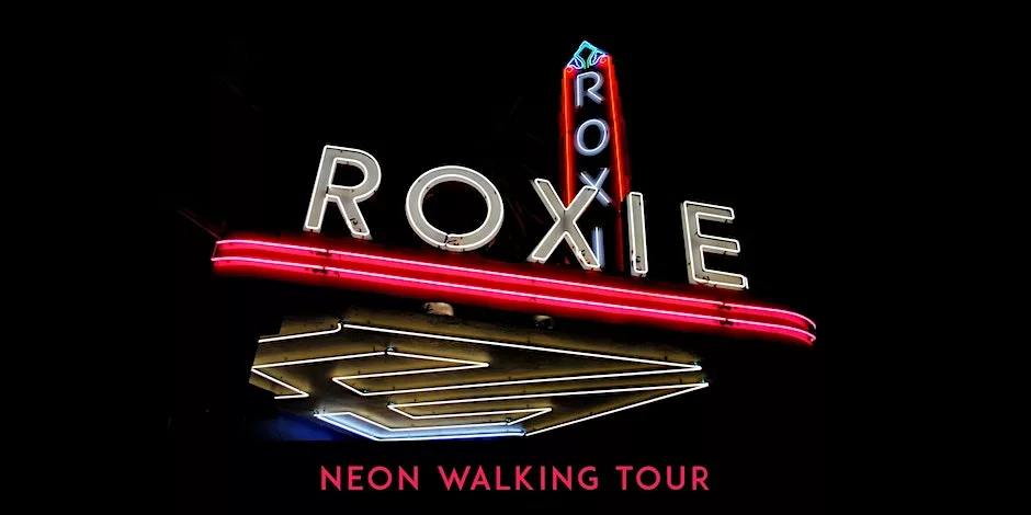 Glowing neon of Roxie marquee lit up with a dark night sky in the bathroom. Text at the bottom says neon walking tour - in bright pink letters.