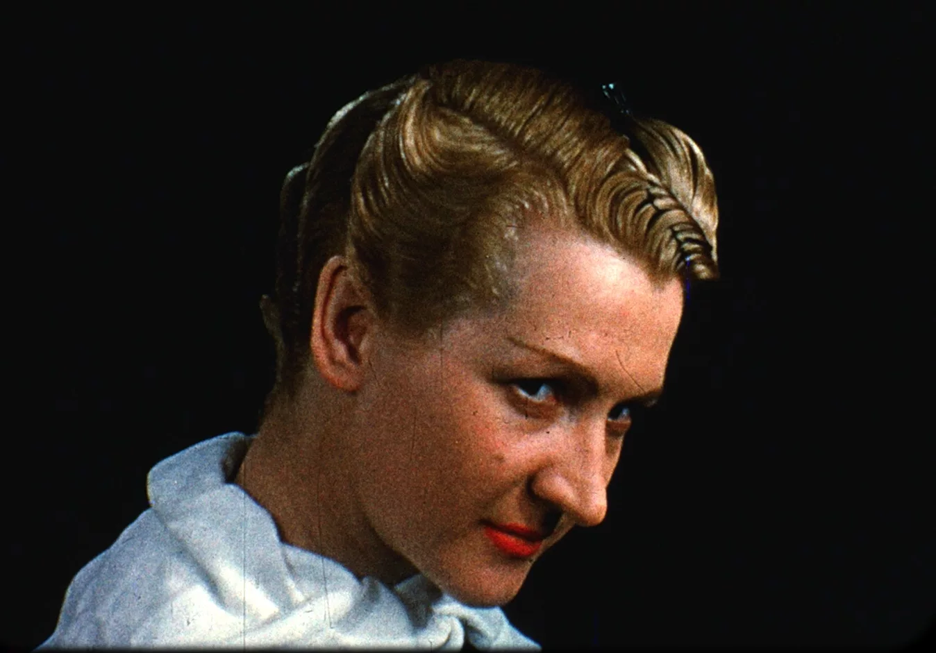 A blonde female with a bob haircut and finger wave stares off to the right