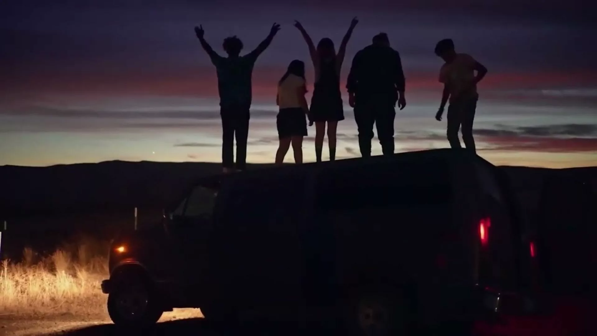 Teenagers standing on a van.