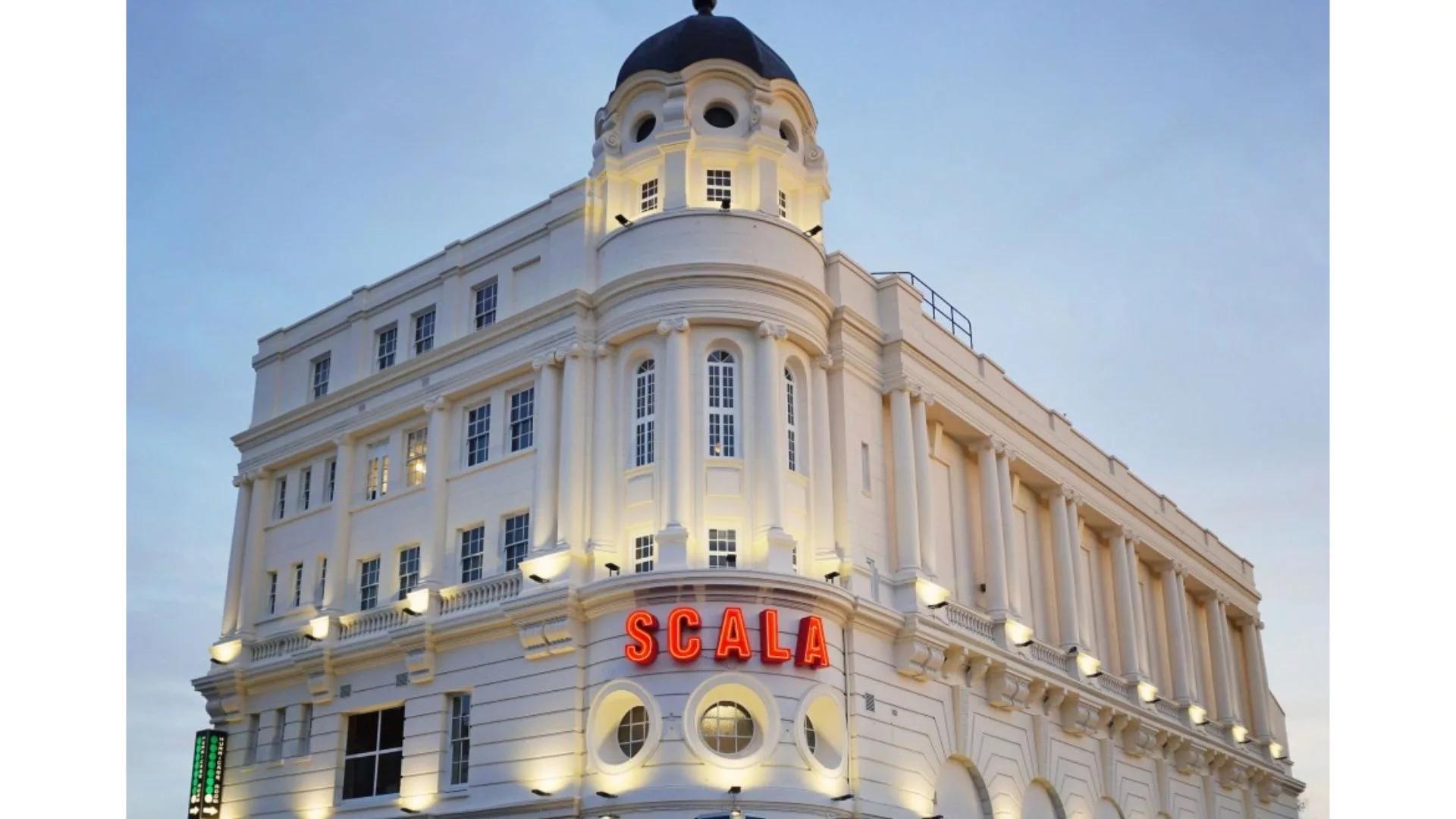 an opulent white building with a marquee in front with the word SCALA