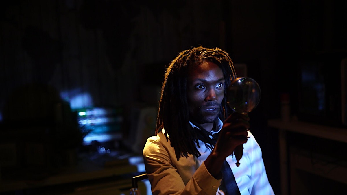 dark room with light reflecting on one person