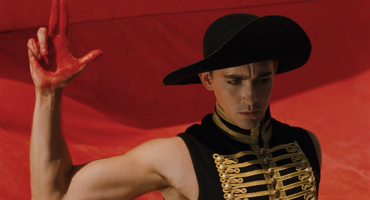 Man with one hand raised with red paint