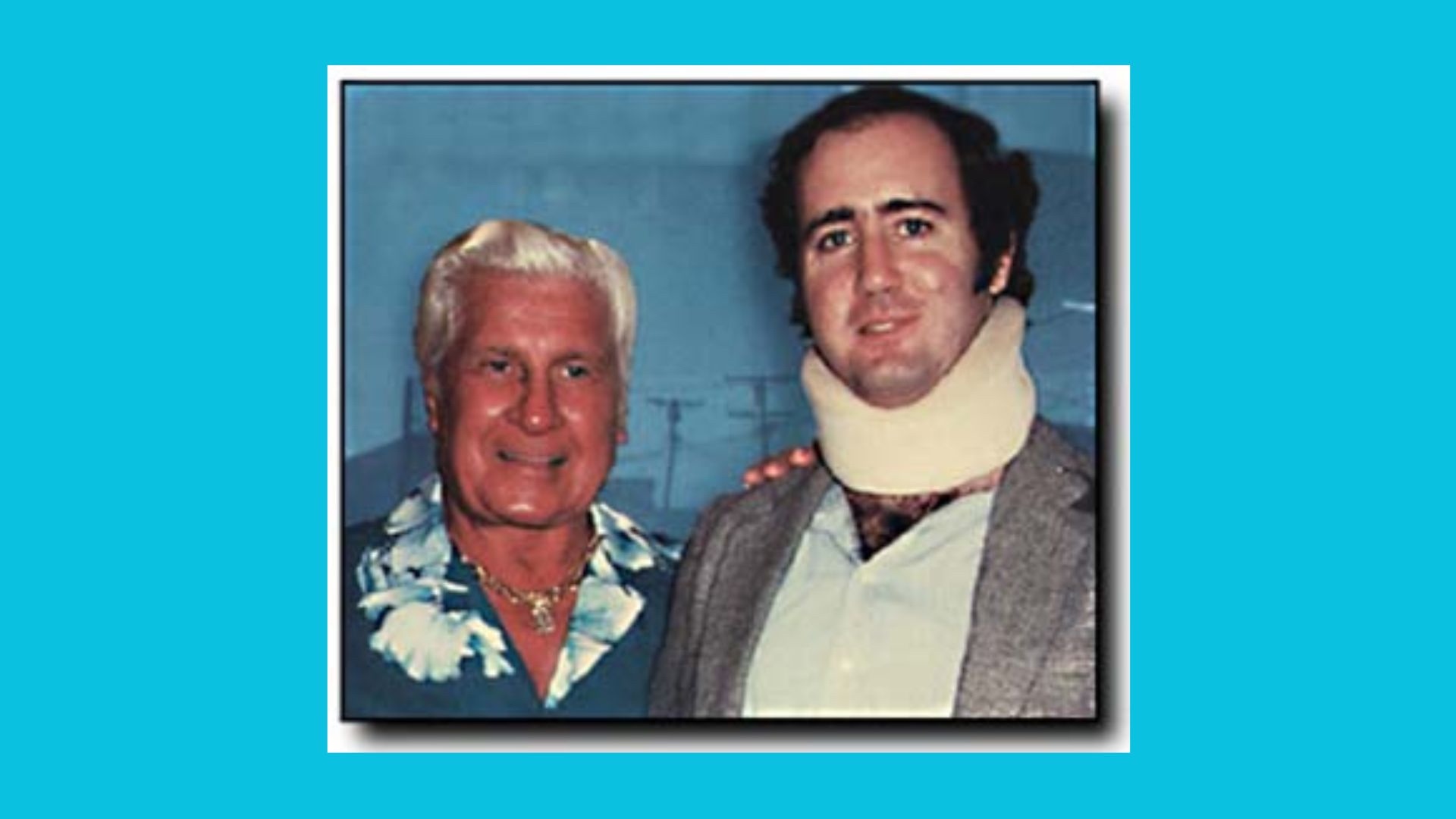 2 white men: 1 with grey hair and an Hawaiian shirt, the other in a neck brace.